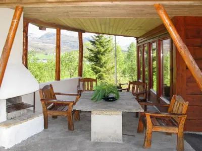 a table and chairs on the porch of a cabin at Chalet Elisabeth by Interhome in Eikelandsosen