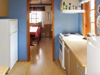a kitchen with blue walls and a white stove top oven at Chalet Elisabeth by Interhome in Eikelandsosen
