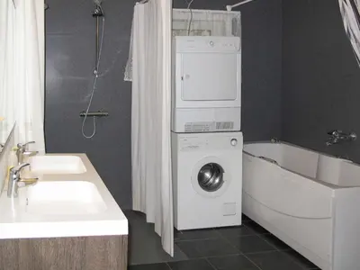a bathroom with a washing machine and a bath tub at Chalet Julie by Interhome in Eikelandsosen