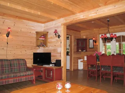 a living room with a television and a dining room at Chalet Julie by Interhome in Eikelandsosen