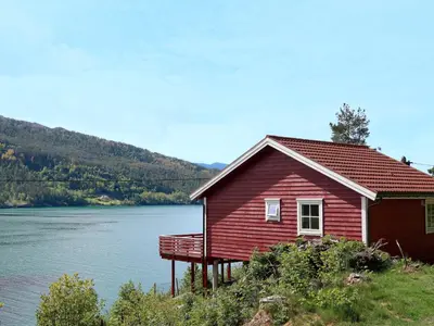 a red house next to a body of water at Holiday Home Rød Hytte by Interhome in Herand