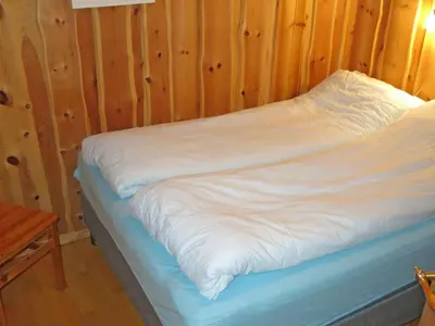 a unmade bed in a room with wooden walls at Chalet Målsnes by Interhome in Balestrand