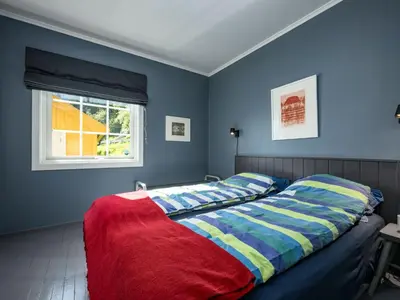 a bedroom with blue walls and a bed with a red blanket at Holiday Home Eseviki by Interhome in Balestrand