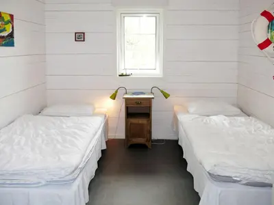 two beds in a room with white walls at Chalet Naustet by Interhome in Balestrand
