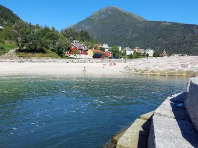 a body of water with a beach and mountains at Holiday Home Naustvollen by Interhome in Balestrand