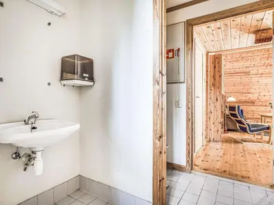 a bathroom with a sink and a wooden door at Holiday Home Veganeset I by Interhome in Balestrand