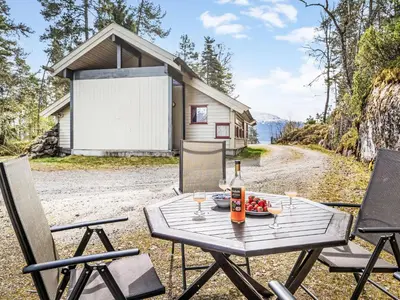 a picnic table with a bottle of wine and a plate of fruit at Holiday Home Veganeset I by Interhome in Balestrand