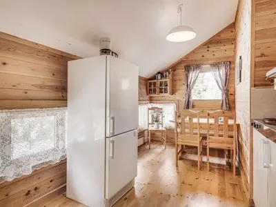 a white refrigerator in a kitchen with a table at Holiday Home Veganeset I by Interhome in Balestrand