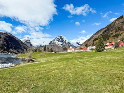 a field of grass with mountains in the background at Holiday Home Tantestova by Interhome in Balestrand