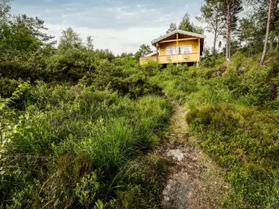 a house on the side of a hill with a dirt road at Holiday Home Granlien by Interhome in Gjølanger