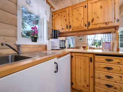 a kitchen with wooden cabinets and a sink at Holiday Home Synnøve by Interhome in Gjølanger