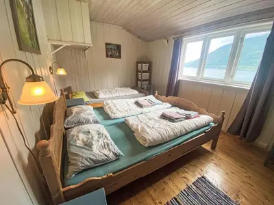 two twin beds in a room with a lamp at Holiday Home Nausthammar by Interhome in Davik