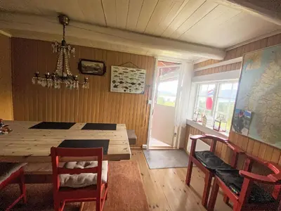 a dining room with a wooden table and chairs at Holiday Home Lenebu by Interhome in Syvde