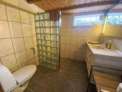 a bathroom with a toilet and a sink at Holiday Home Lenebu by Interhome in Syvde