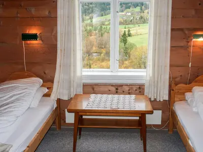 a room with two beds and a window and a table at Holiday Home Elvehuset by Interhome in Holsen