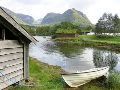a boat parked next to a building next to a river at Holiday Home Elvehuset by Interhome in Holsen
