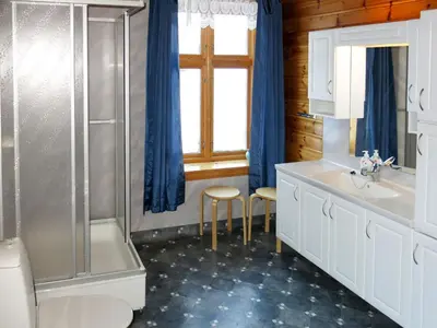 a bathroom with a toilet and a sink and a shower at Holiday Home Elvehuset by Interhome in Holsen