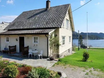a house with a patio and a view of the water at Holiday Home Kvamsvika by Interhome in Kvammen