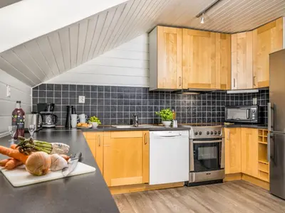 a kitchen with wooden cabinets and a counter with vegetables on it at Holiday Home Frigg by Interhome in Arnefjord