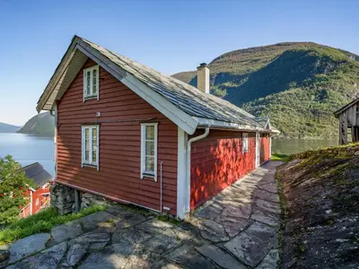a red house with a mountain in the background at Holiday Home Johans Maria stova by Interhome in Arnefjord
