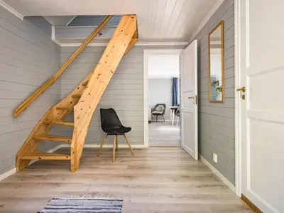 a staircase in a house with a black chair at Holiday Home Tor by Interhome in Arnefjord