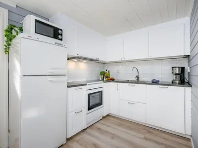 a kitchen with white cabinets and a white refrigerator at Holiday Home Tor by Interhome in Arnefjord