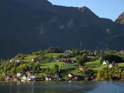 a village on a hill next to a body of water at Holiday Home Odin by Interhome in Arnefjord