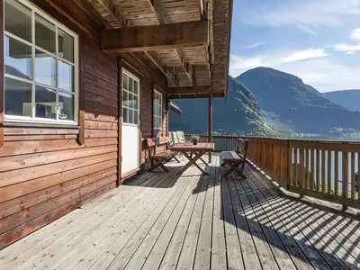 a wooden deck with a table and chairs on a house at Holiday Home Odin by Interhome in Arnefjord