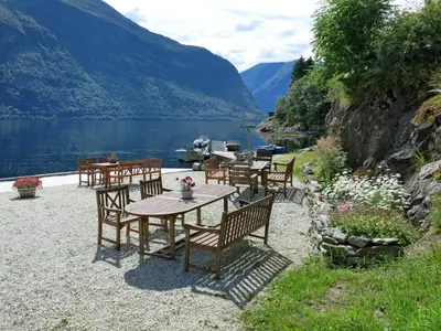 a table and chairs with a view of a lake at Apartment Fagerdalsnipi by Interhome in Arnefjord