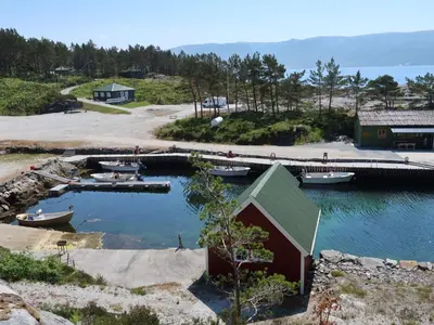 a group of boats in a harbor with a dock at Holiday Home Solsvika by Interhome in Leirvik