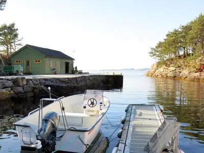a boat is docked at a dock in the water at Holiday Home Solsvika by Interhome in Leirvik