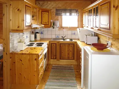 a kitchen with wooden cabinets and a white refrigerator at Holiday Home Nanna by Interhome in Hyllestad