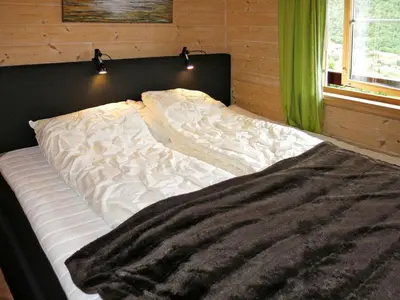 an unmade bed in a room with green curtains at Holiday Home Peer Gynt by Interhome in Sogndal