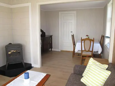 a living room with a stove and a table at Holiday Home Strøneneset by Interhome in Hagavik