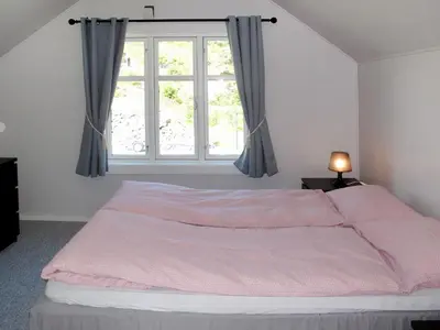a bedroom with a pink bed with a window at Holiday Home Strøneneset by Interhome in Hagavik