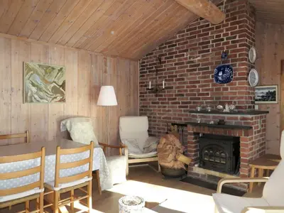 a living room with a brick fireplace and a table and chairs at Holiday Home Hjartnesvika by Interhome in Hjartåker