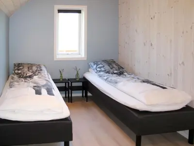 two beds sitting in a room with a window at Apartment Gurevika by Interhome in Nordhuglo