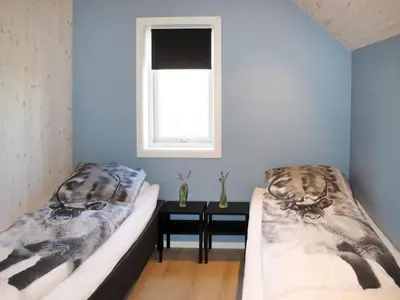 two beds in a room with a window and a table at Apartment Gurevika by Interhome in Nordhuglo