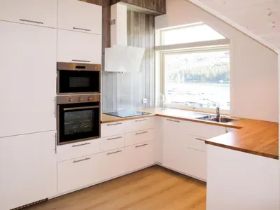 a kitchen with white cabinets and a window at Apartment Gurevika by Interhome in Nordhuglo