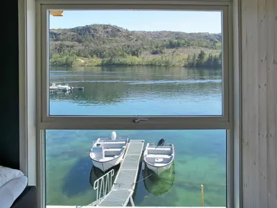 a window view of a lake with boats in the water at Apartment Gurevika by Interhome in Nordhuglo