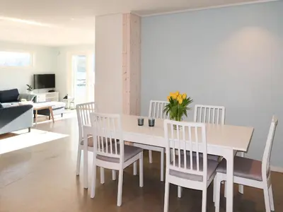 a white dining room with a white table and chairs at Apartment Huglavika by Interhome in Nordhuglo