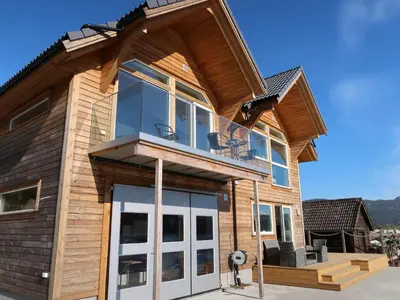 a house with glass doors and a roof at Apartment Huglavika by Interhome in Nordhuglo