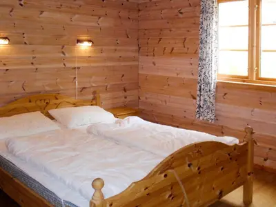 a wooden bed in a room with a window at Chalet Eiknes by Interhome in Tjoflot