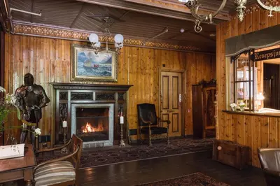 a living room with a fireplace and a chair at Hotel Union Øye in Øye