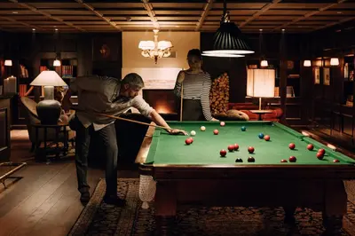 a man playing pool in a living room at Hotel Union Øye in Øye