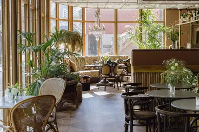 a restaurant with tables and chairs and plants at Hotel Union Øye in Øye