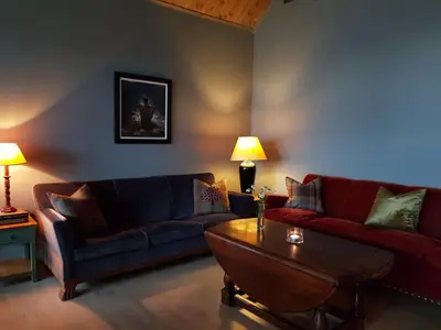 a living room with two couches and a coffee table at Villa Fjara sleeps 22 in 6 bedrooms in Ulven