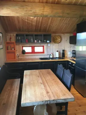 a kitchen with a wooden table and a refrigerator at Nilsrud 30 Feriehus in Åmotsdal