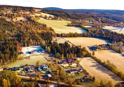 an aerial view of a farm with trees and a river at Cabin with great view close to town and ski area in Lillehammer