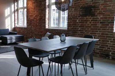 a table and chairs in a room with a brick wall at Nygårdsgaten apartments in Bergen